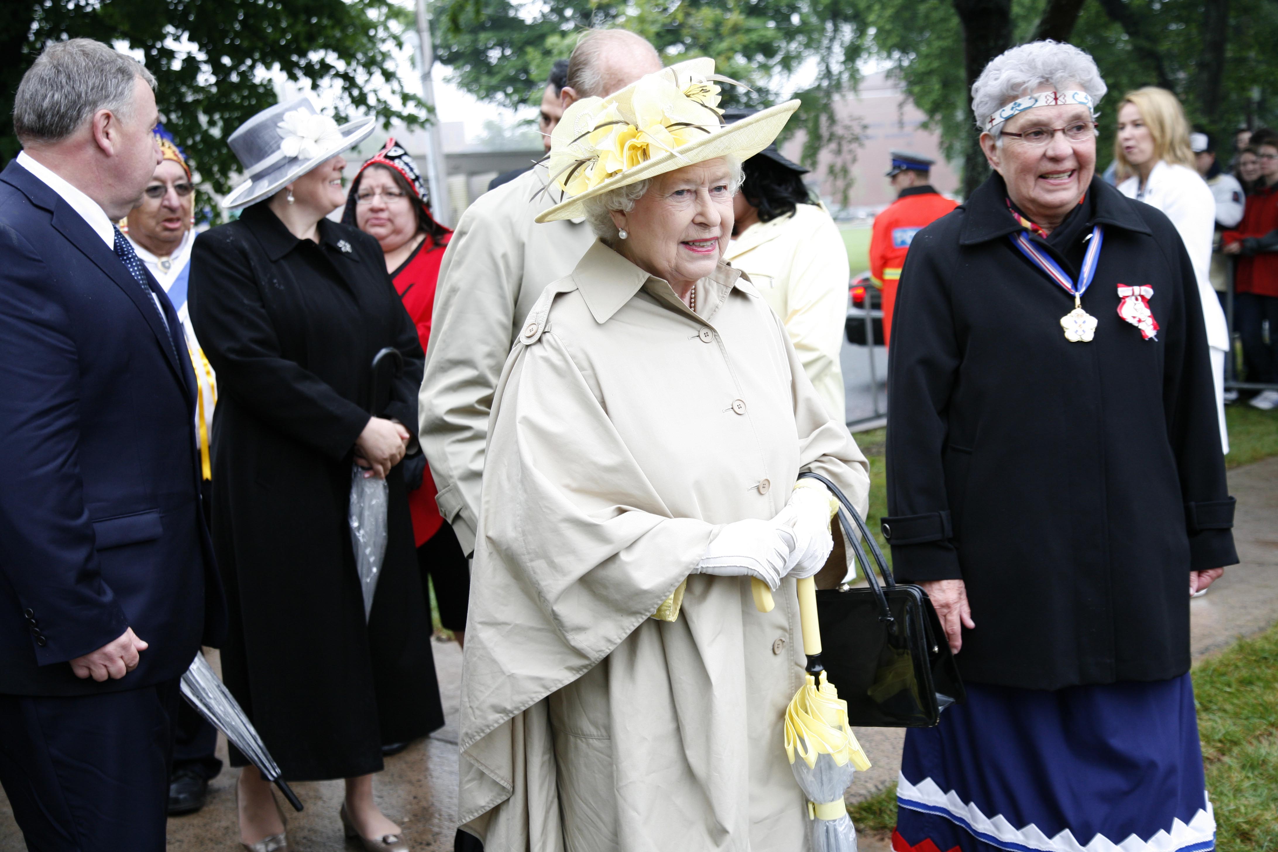 After arriving at the Halifax Commons, Queen Elizabeth walks with Sister Dorothy Moore to the Mi'kmaq cultural event where she met other elders and was presented with a painting by artist Alan Syliboy.